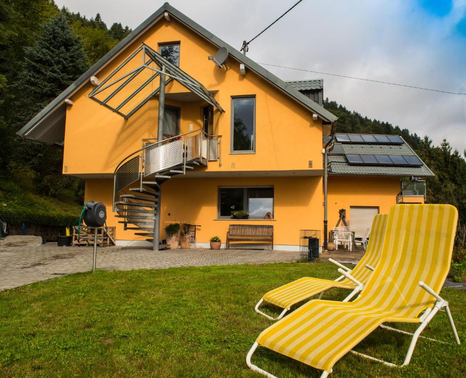 a pair of chairs in front of a house at Ferienwohnung Roos in Klüsserath