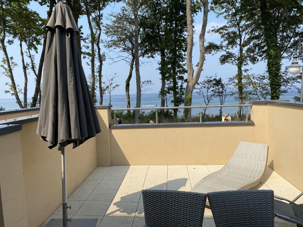 an umbrella and two chairs on a balcony at Apartamenty AMALIA in Rewal
