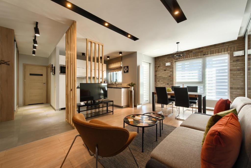 a living room with a couch and a table at Malta Apartament Parking by IMPERO in Poznań