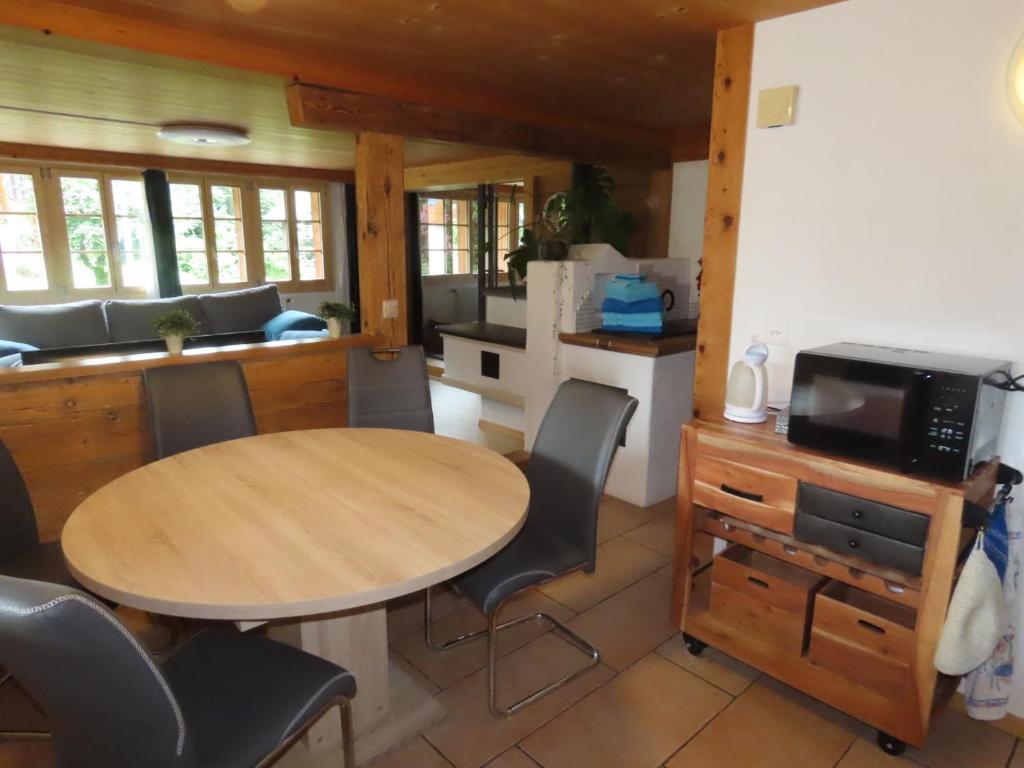 een keuken met een tafel en stoelen in een kamer bij Holzhaus bei Interlaken in Goldswil