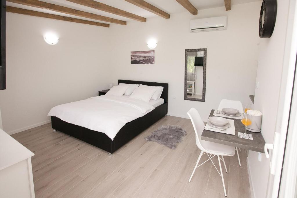 1 dormitorio con 1 cama y 1 mesa con sillas en Studio apartments Tara en Zadar