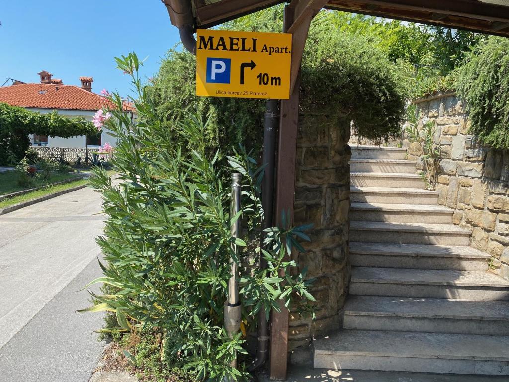 un panneau de stationnement jaune sur le côté d'une rue dans l'établissement Maeli Apartment, à Lucija