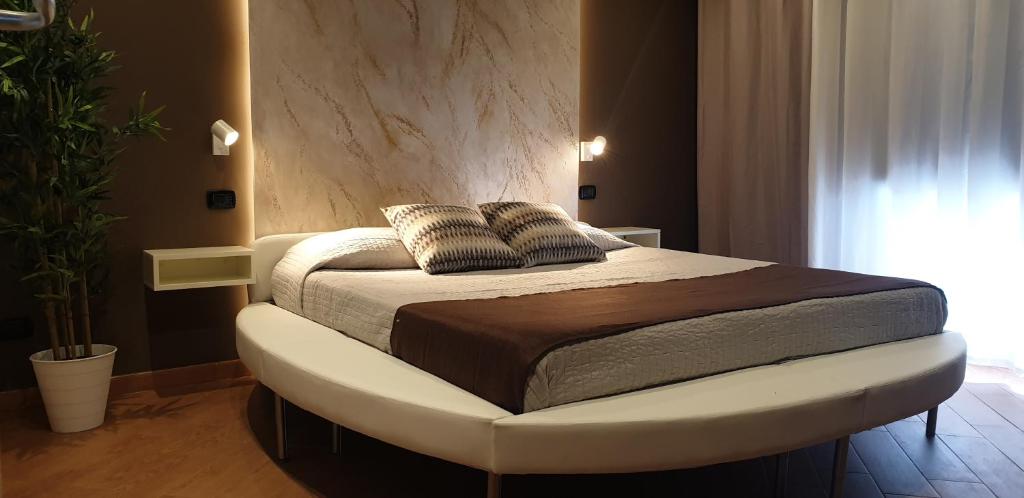 a bedroom with a bed with a white foot board at TH LUXURY fly in Catania