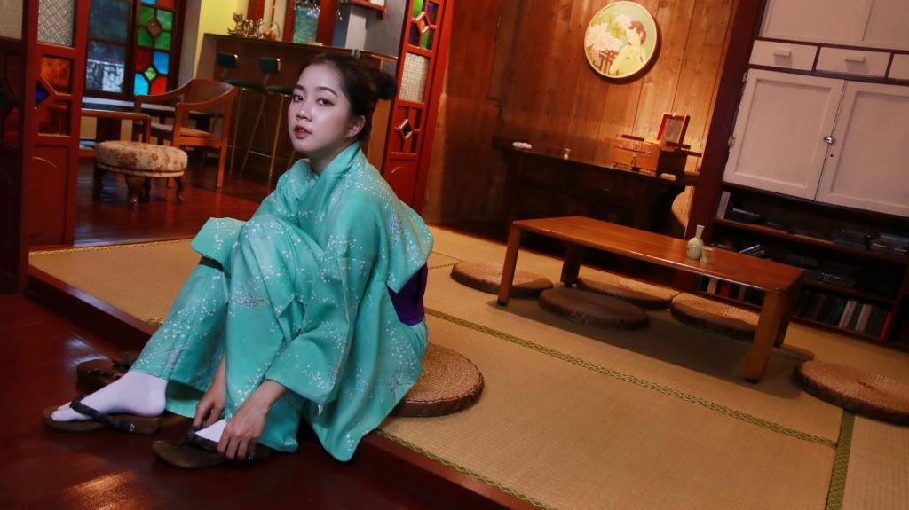 een pop van een vrouw die op een tafel zit bij A Touch of Zen in Kaohsiung