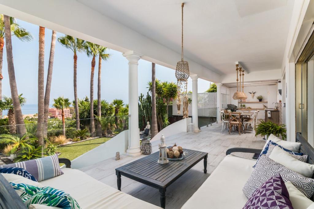 une terrasse avec des palmiers et une table dans l'établissement Casa Blanca, à Manilva