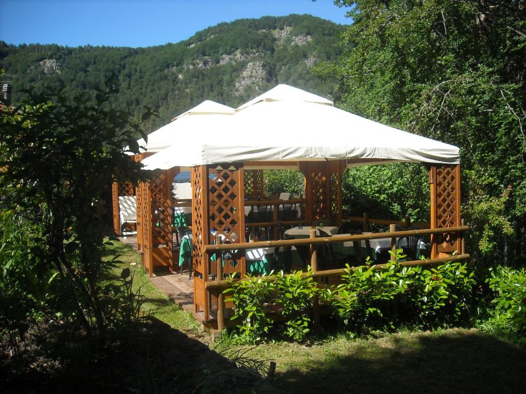 a wooden gazebo with a white umbrella at La Villa in Abetone