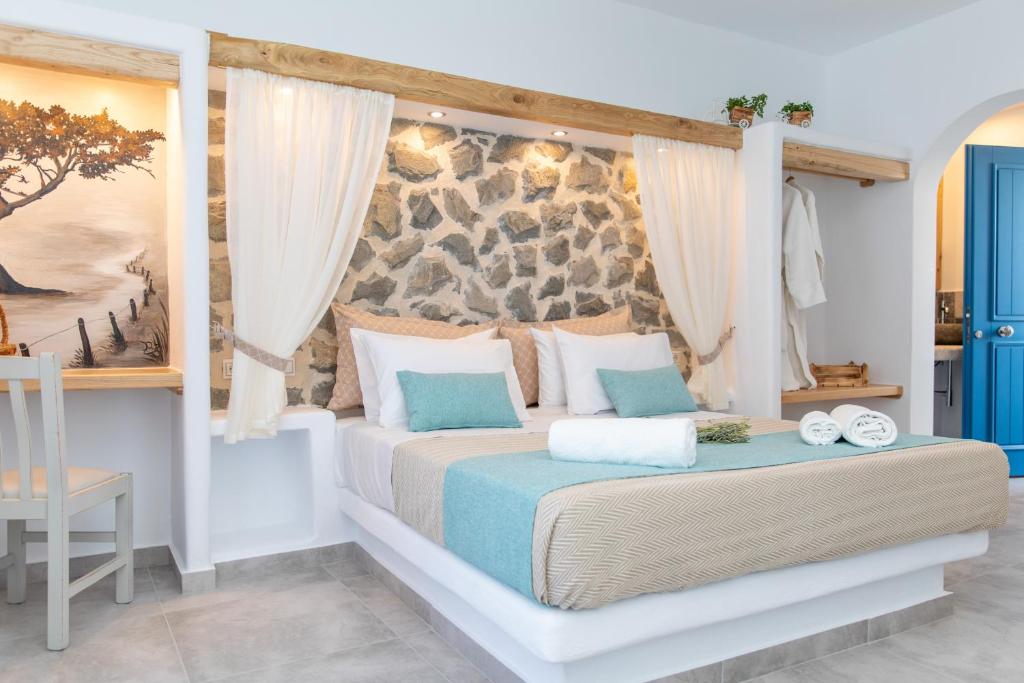 ein Schlafzimmer mit einem Bett mit einer Steinmauer in der Unterkunft Arhontiko in Naxos Chora