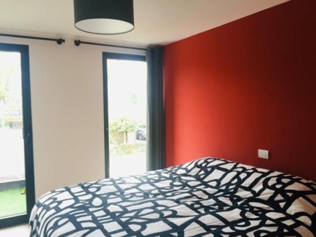 a bedroom with a black and white bed and red walls at HYTTA in Arendonk