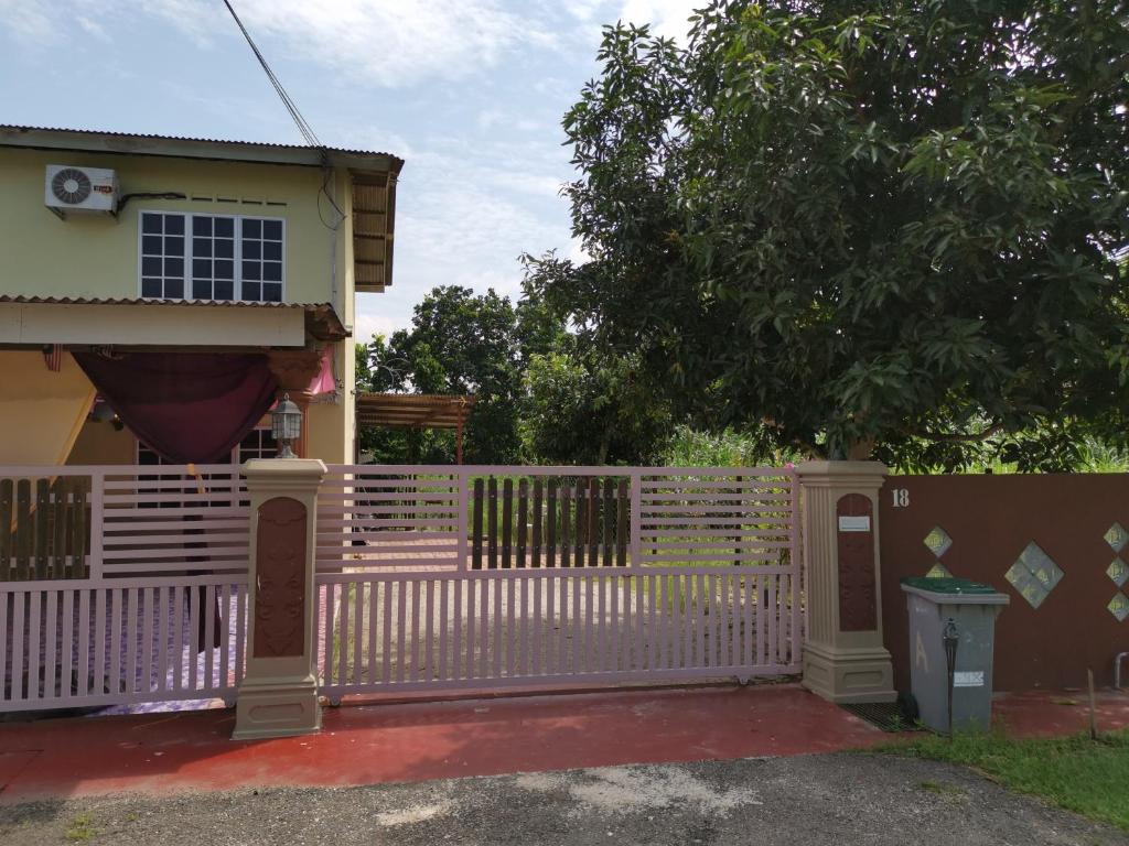 a white fence in front of a house at Sri Makmur Pontian Homestay in Pontian Besar
