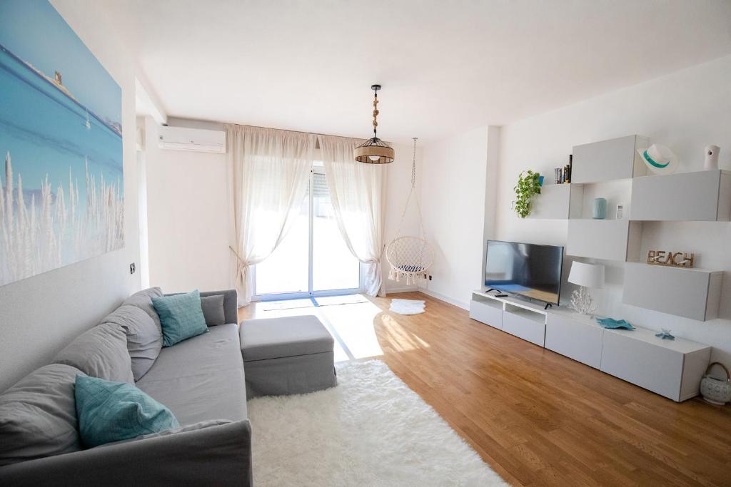 ein Wohnzimmer mit einem Sofa und einem TV in der Unterkunft Bay View Apartment in Porto Torres