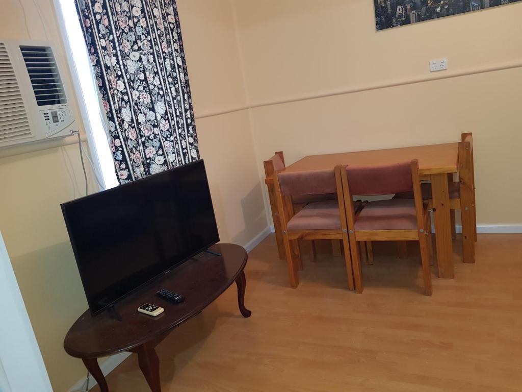 a living room with a table and a tv and a tableablish at AGVA OPAL in Coober Pedy