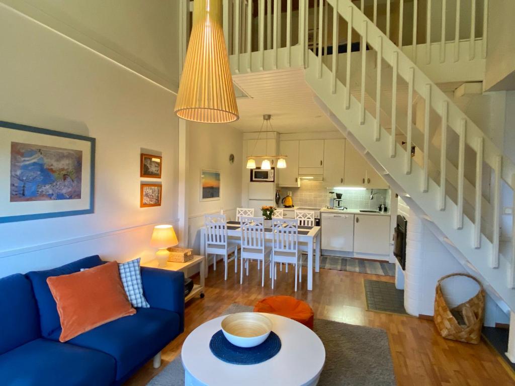 a living room with a blue couch and a kitchen at Herranterttu Apartments in Saariselka