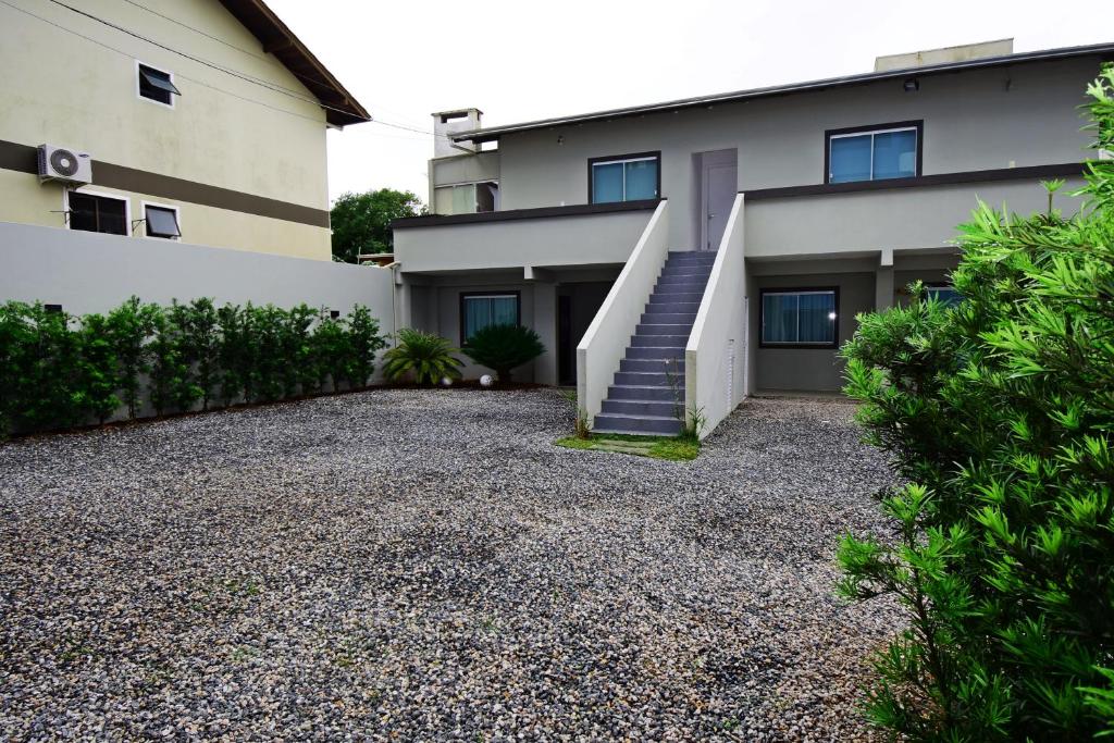 a house with a staircase and a gravel driveway at Morada Pinheiro 160m da Praia in Bombinhas