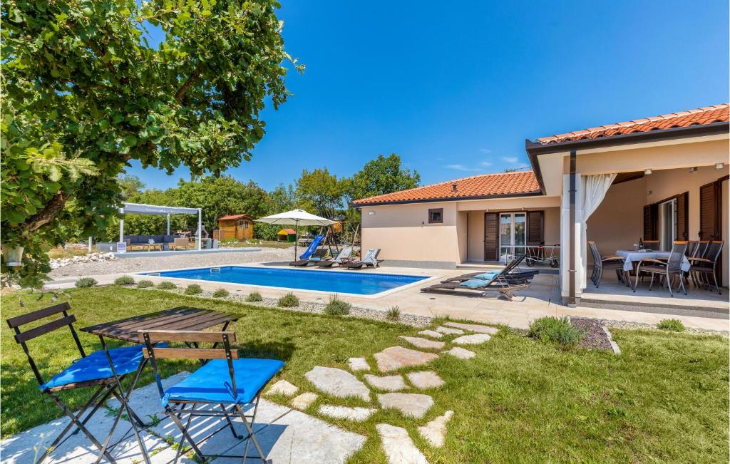 un cortile con tavolo, sedie e piscina di Beautiful Home In Kunj With Wifi a Kunj