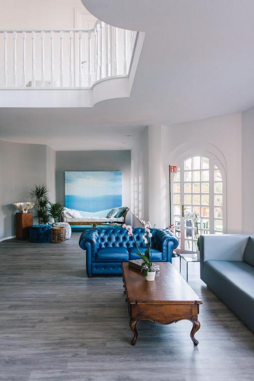 a living room with blue couches and a coffee table at Mami Sabaudia Hotel in Sabaudia