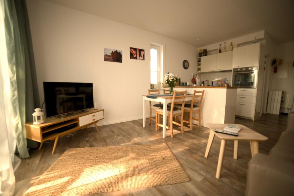 a living room with a table and a kitchen at Schöne Ferienwohnung Breege in Breege