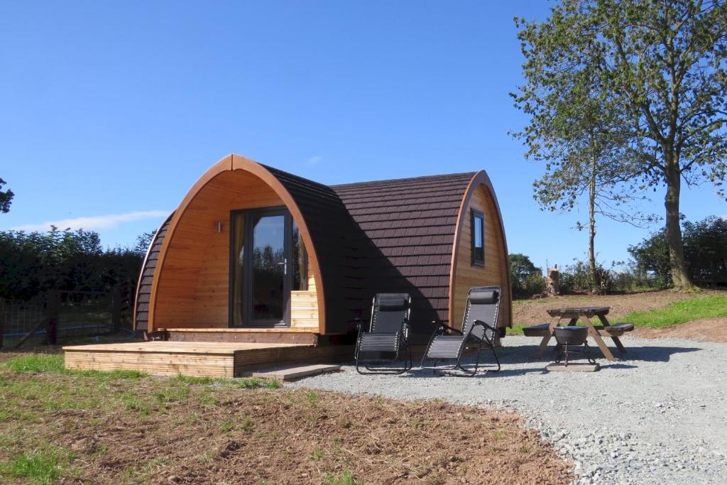 a small wooden cabin with a table and two chairs at Cheshire View in Ellesmere