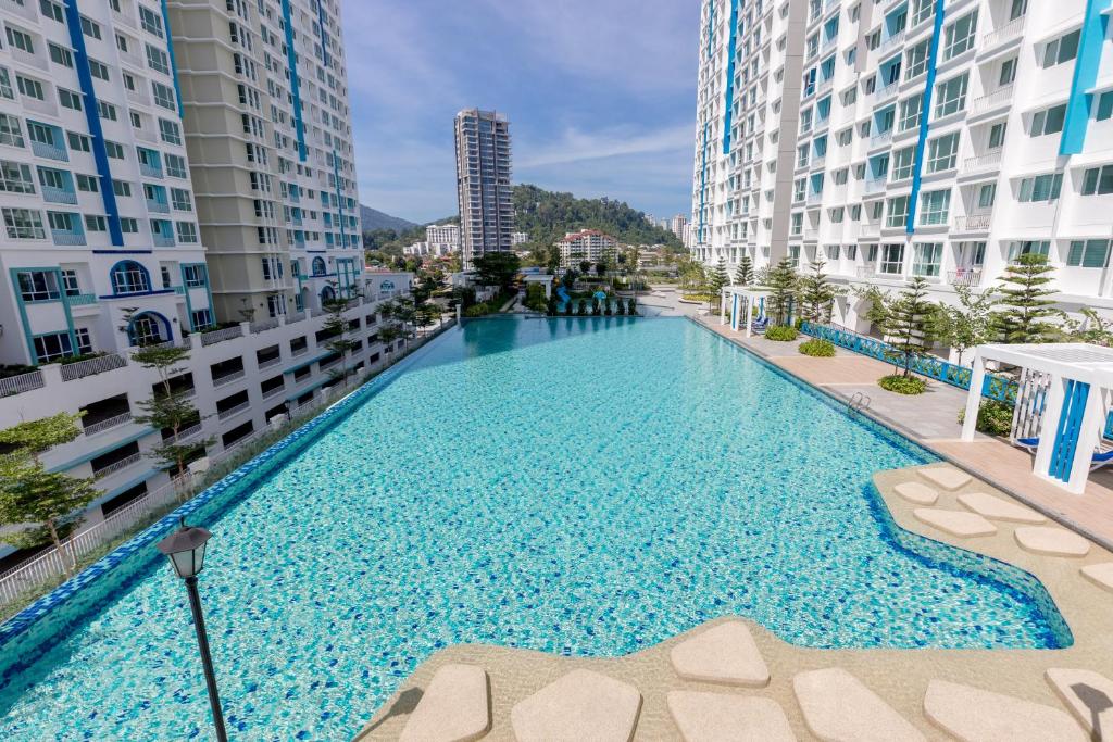 een groot zwembad in het midden van sommige gebouwen bij Seaview Holiday Home, by Sanguine in Tanjong Tokong