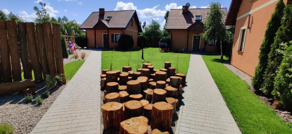 a pile of logs in a yard next to a house at Wczasy u Reni in Kopalino