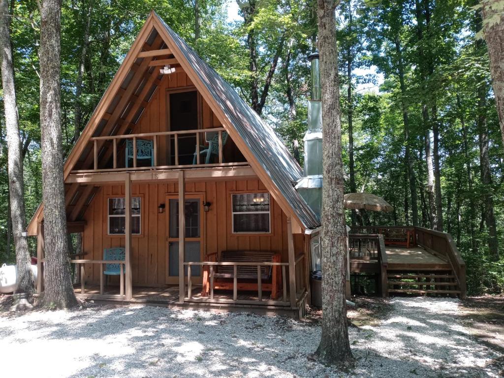 eine Blockhütte im Wald mit einem Baum in der Unterkunft Tranquil Oaks Cabin in Wellington