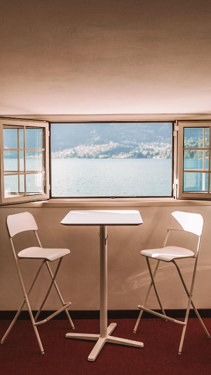 two chairs and a table in front of a window at Casa Zoe in Lezzeno