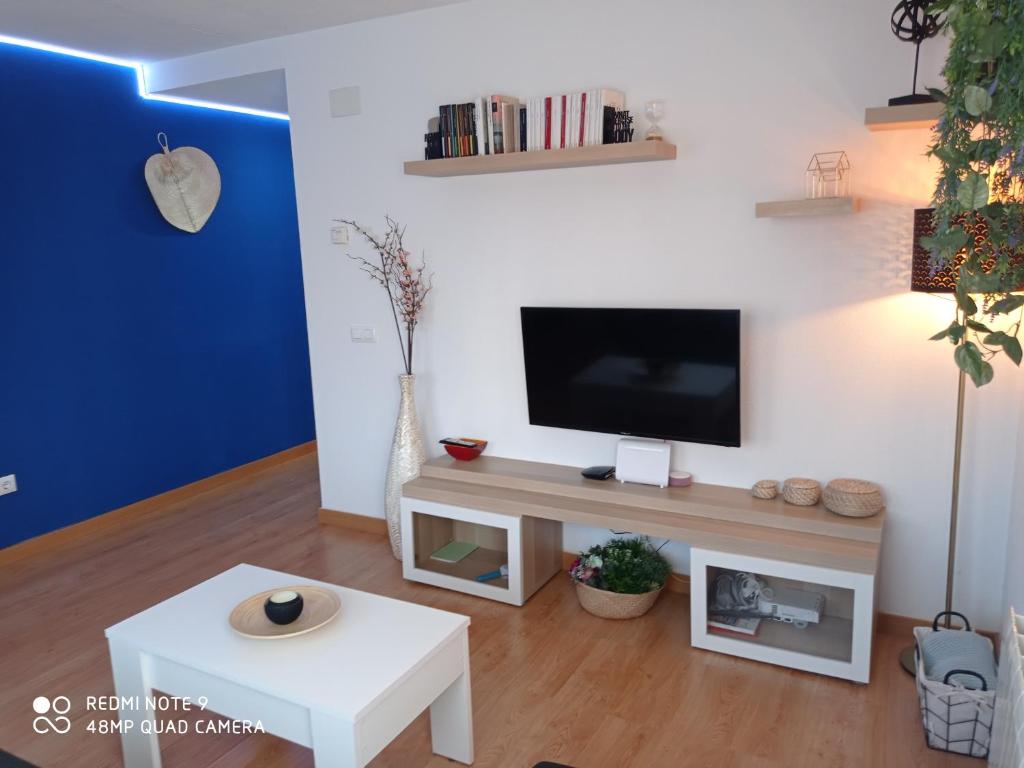 ein Wohnzimmer mit einem Flachbild-TV an der Wand in der Unterkunft Deep Blue Inn in Torrecaballeros