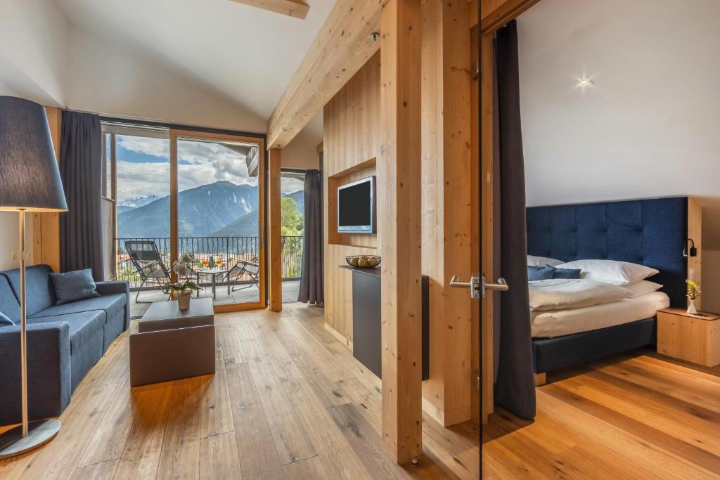 a bedroom with a bed and a view of a mountain at Maraias - Luxury Suites & Apartments in Burgusio