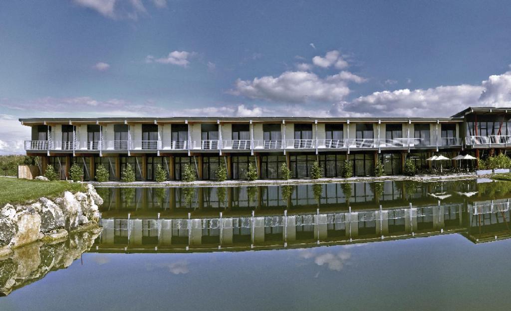 un edificio con un reflejo en el agua en Sand Martin, en Mladá Boleslav