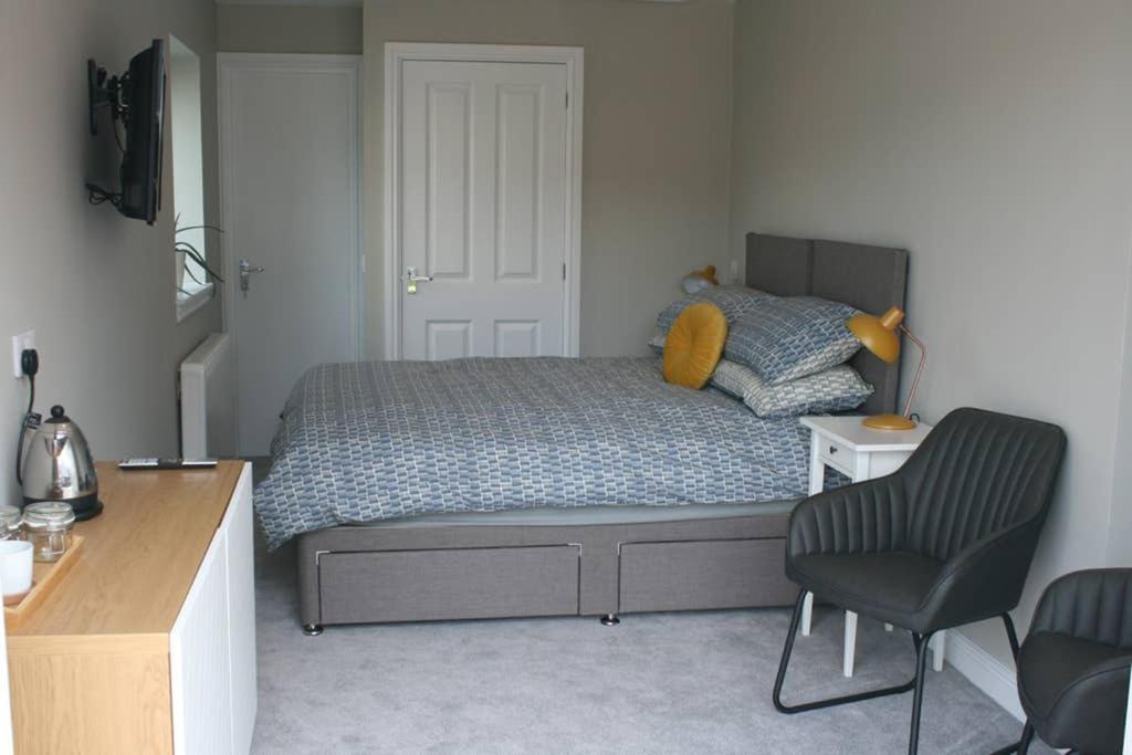 a bedroom with a bed and a desk and a chair at The Snug at the Ski Lodge, Aviemore in Aviemore