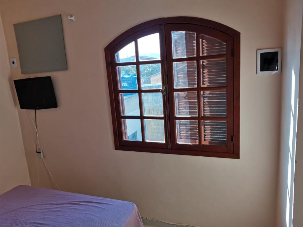 1 dormitorio con ventana y 1 cama. en Casa a 3 minutos da praia, en Saquarema