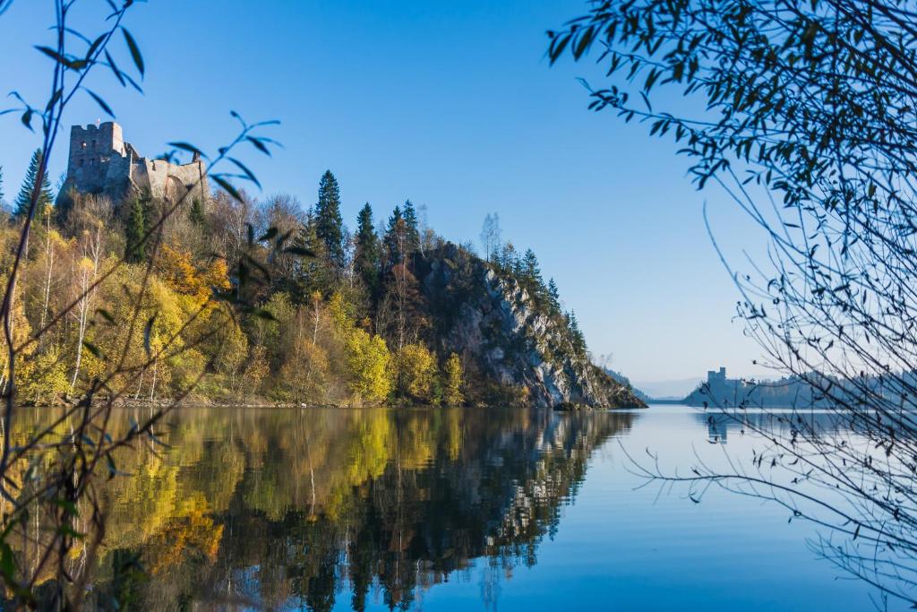 a view of a lake with a castle in the background at Pokoje u Jana in Czorsztyn