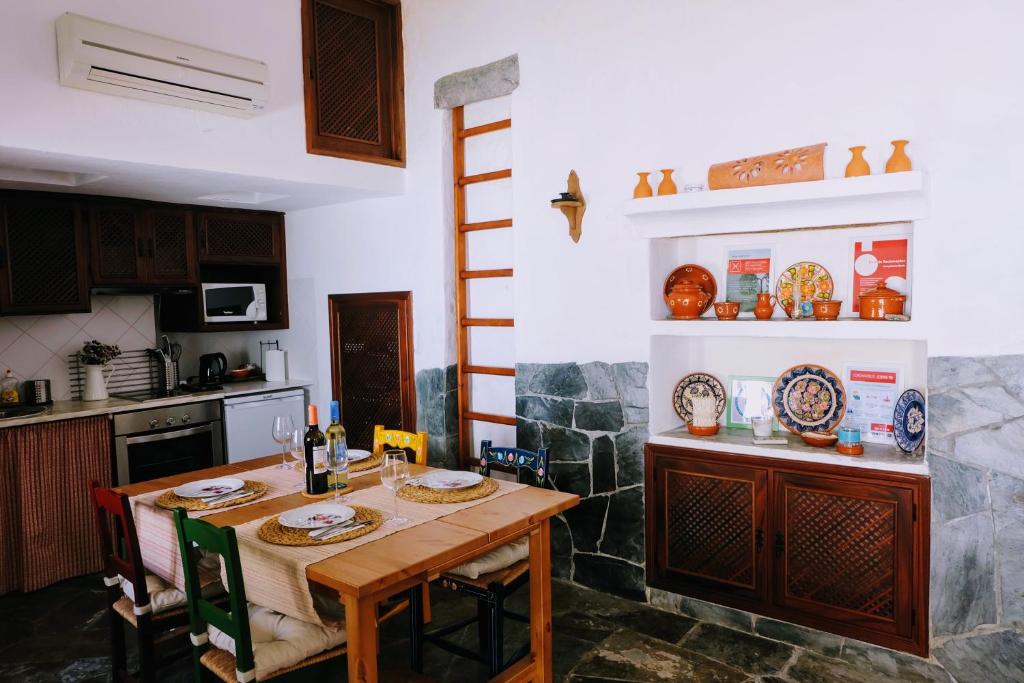 a kitchen with a wooden table with plates on it at Casa das Videiras in Monsaraz
