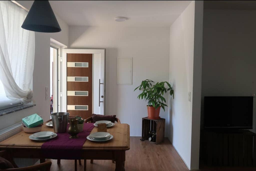 a living room with a wooden table with plates on it at GRÜNER HAUS in Gampern