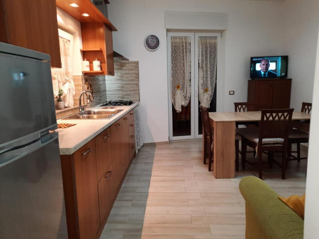 Il comprend une cuisine avec un évier et une table avec une télévision. dans l'établissement GUEST HOME, à Ischia