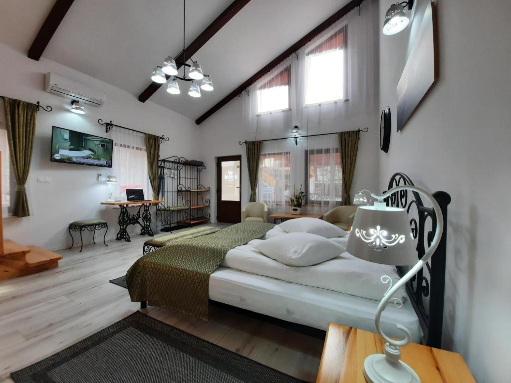 - une chambre avec un lit dans une pièce dotée de fenêtres dans l'établissement Korona Panzió, à Odorheiu Secuiesc