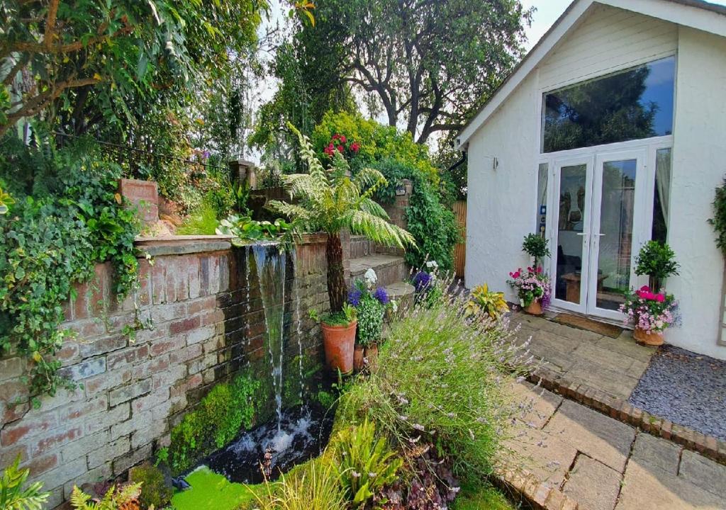 uma casa com um jardim com uma fonte no quintal em No1 The Smithy em Tattenhall