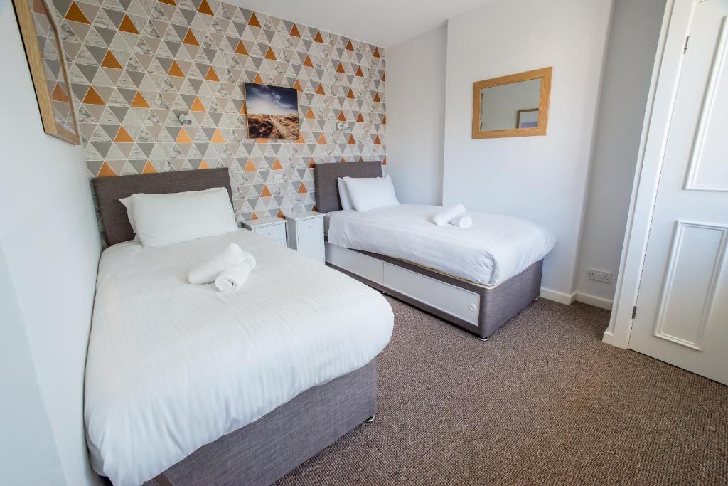 a hotel room with two beds and a window at Sea Road Apartments in Bournemouth