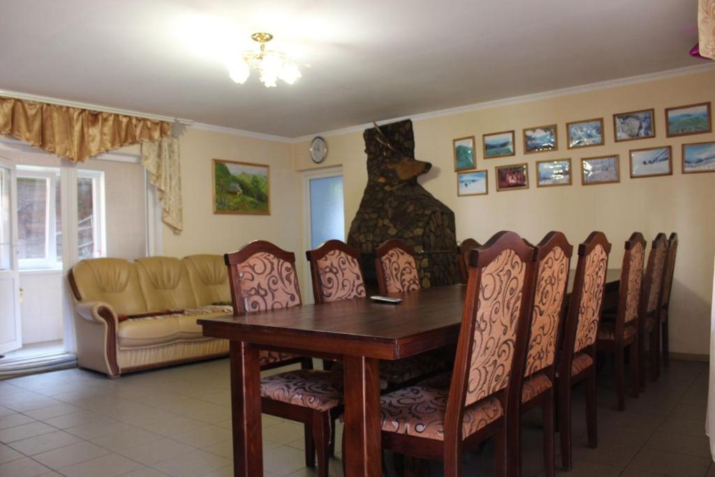 a dining room with a table and chairs and a couch at Садиба У Йосипа in Ustʼ-Chorna