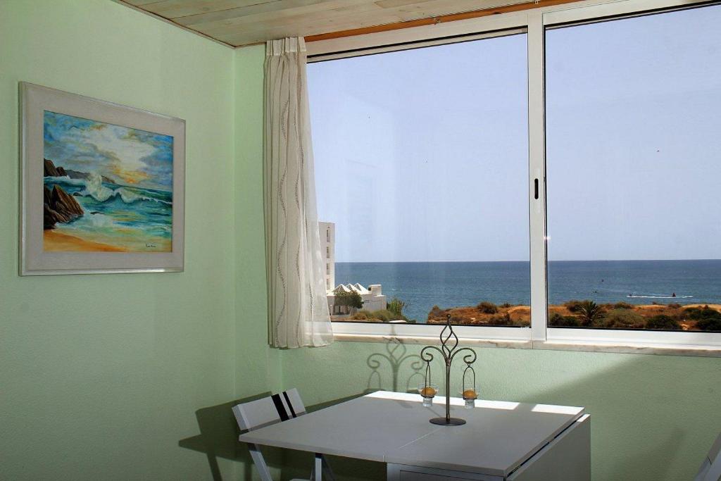 a dining room with a table and a large window at Marisol 2F Waterfront in Armação de Pêra