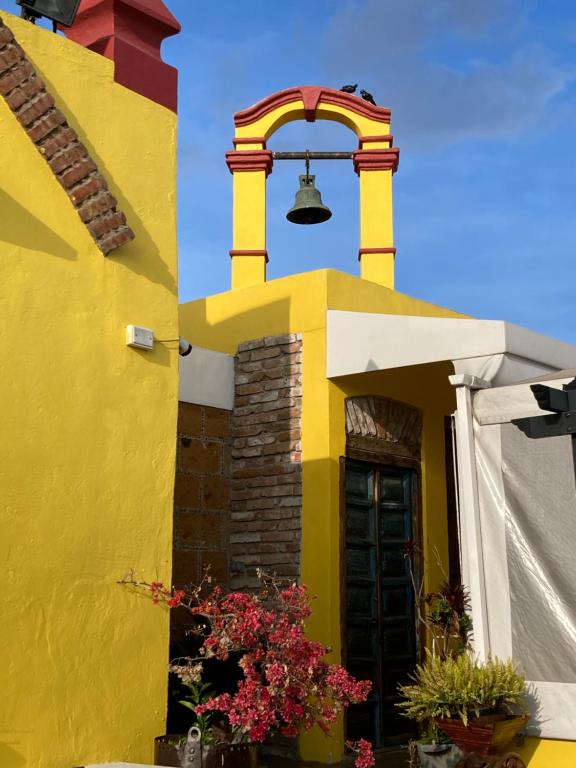 un edificio giallo con un campanello di Hotel Boutique Posada XVII a Puebla