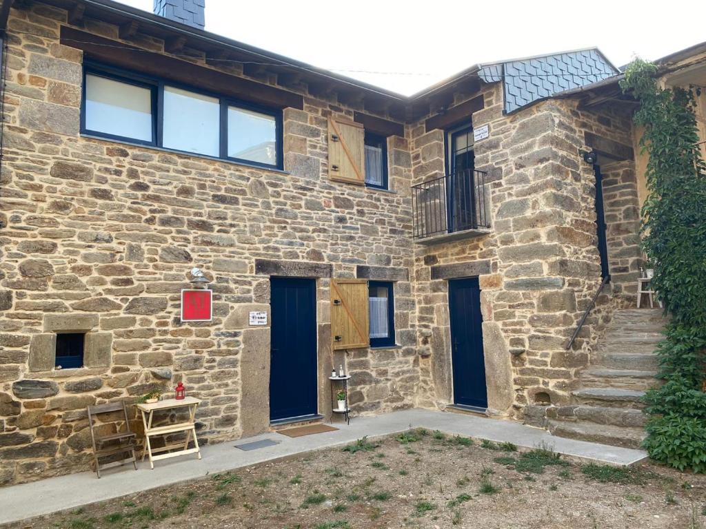 un edificio de ladrillo con puertas azules y una silla en la parte delantera en CURATO EL HORNO, en Trefacio