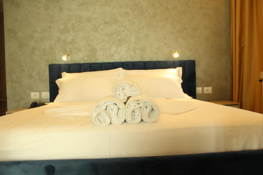 a bed with two towels on top of it at Hotel Triumf Shengjin in Shëngjin
