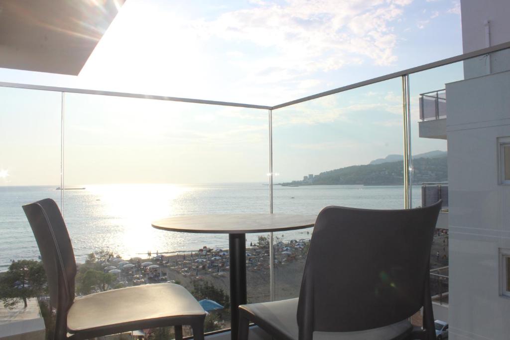 a balcony with a table and chairs and the ocean at Hotel Triumf Shengjin in Shëngjin