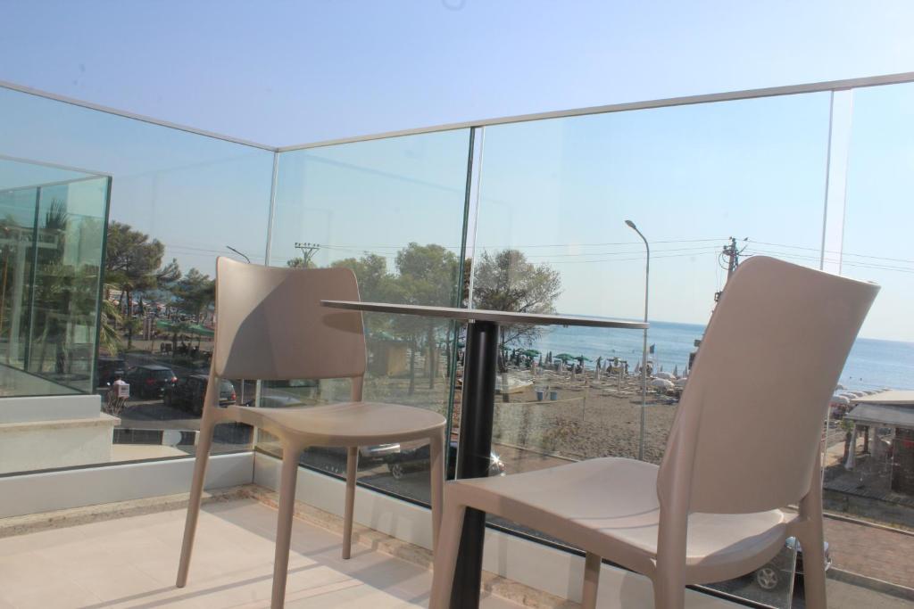 two chairs and a table on a balcony at Hotel Triumf Shengjin in Shëngjin