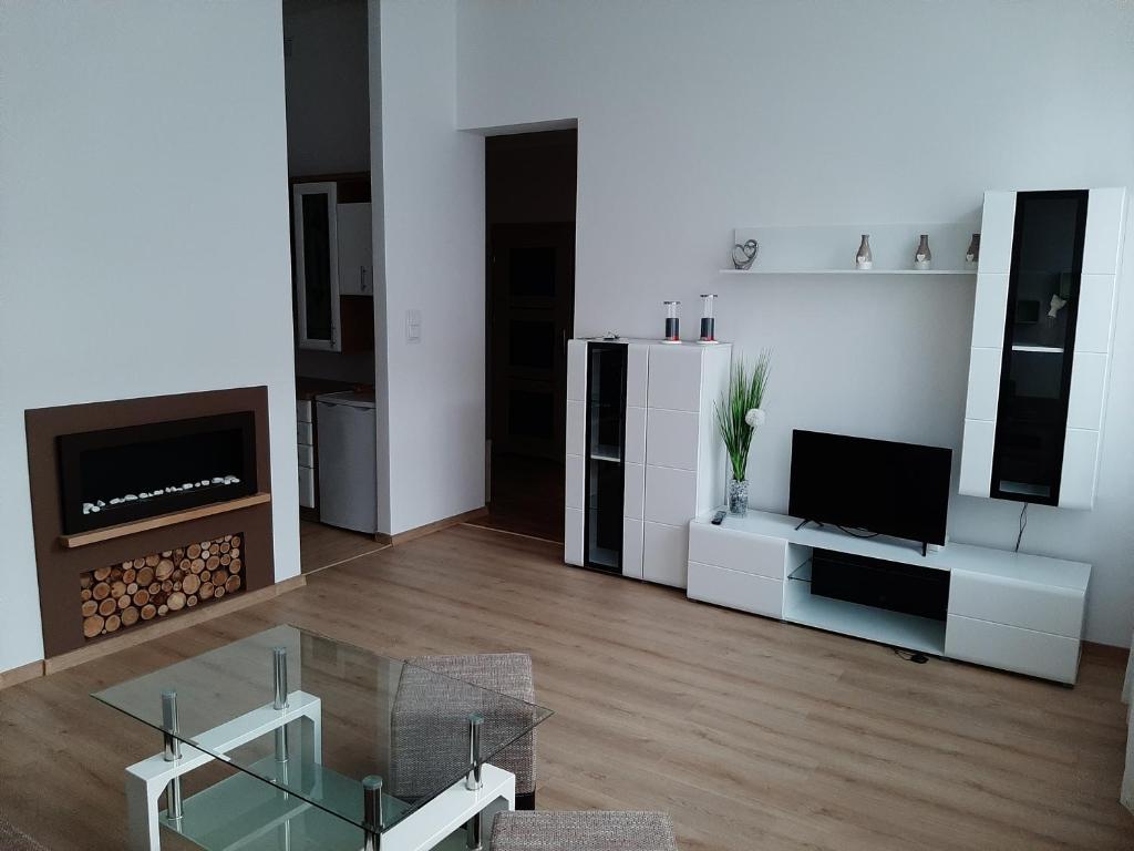 a living room with a glass table and a television at Apartament nad Jeziorem Olecko in Olecko