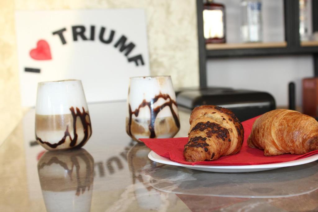 a table with two glasses and a plate of bread at Hotel Triumf Shengjin in Shëngjin
