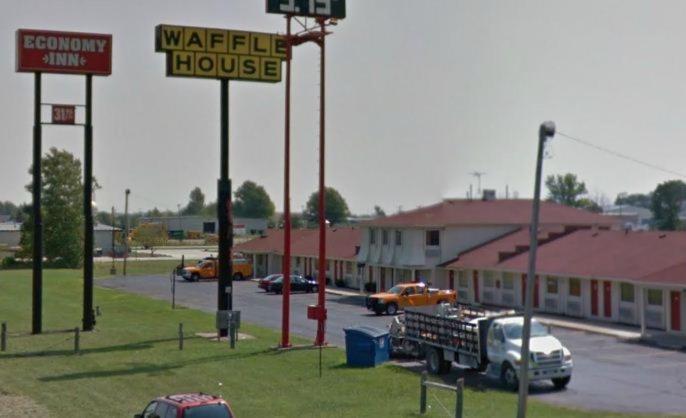 una señal para una casa de mercado con un camión en un estacionamiento en Economy Inn Toledo-Perrysburg, en Perrysburg