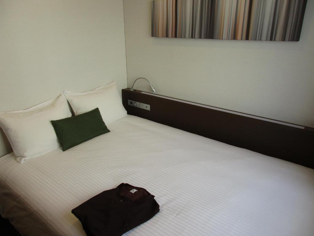 Postel nebo postele na pokoji v ubytování Y's HOTEL Shin Osaka