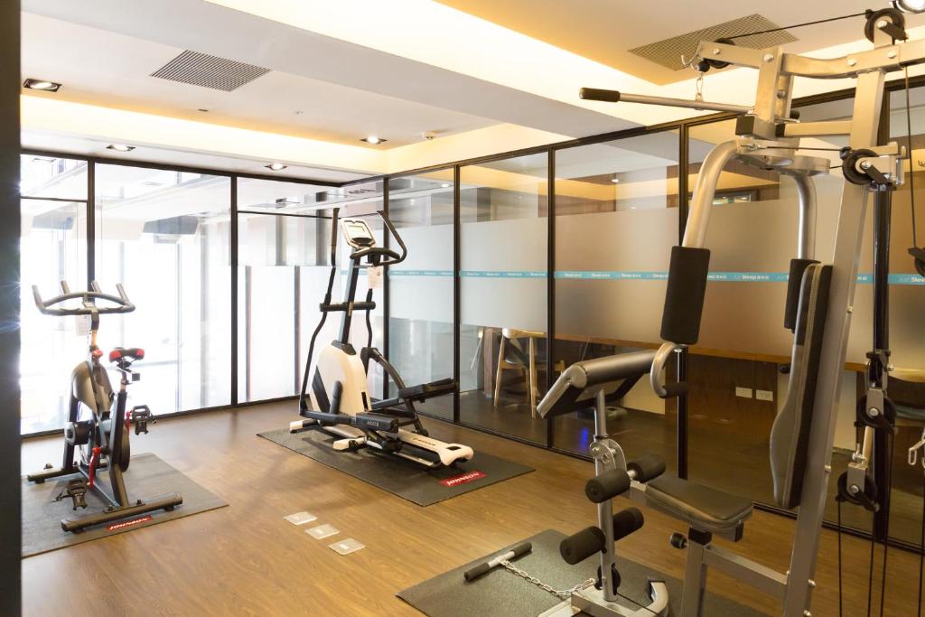 a gym with treadmills and ellipticals in a room at Just Sleep Kaohsiung Zhongzheng in Kaohsiung
