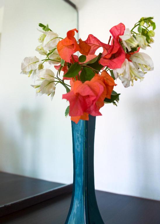 a blue vase with red and white flowers in it at Villa Karingal in Senggigi